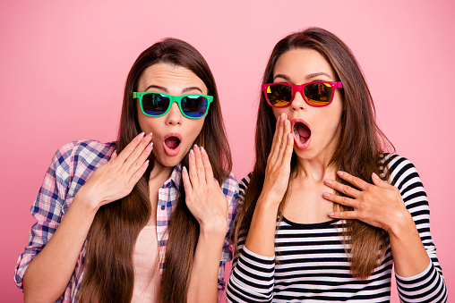 Really Close up portrait crazy funny hipsters eye glasses impressed incredible news cant believe scream shout touch hand cheek mouth wear bright modern clothes isolated rose-colored background.