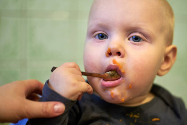 istock Little baby learn to eat by yourself with a spoon 1141935487