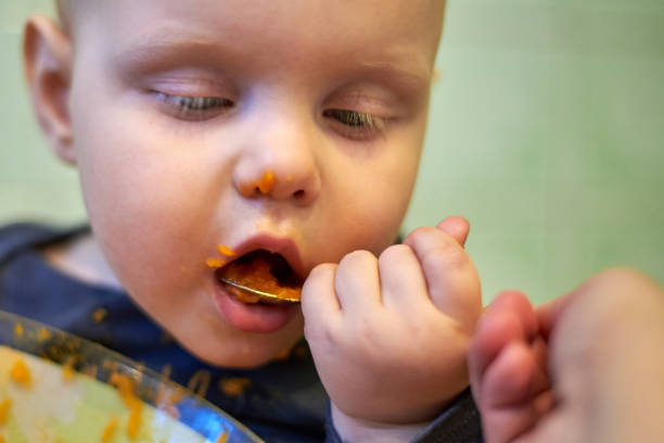 istock Little baby learn to eat by yourself with a spoon 1141935742