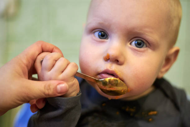 istock Little baby learn to eat by yourself with a spoon 1141937487