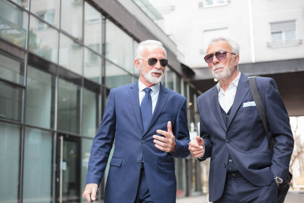 istock Two senior businessmen walking down the street, discussing 1141938921