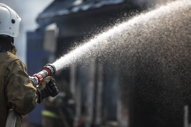 istock Fireman spraying water in a smouldering burnt out house 1141945513