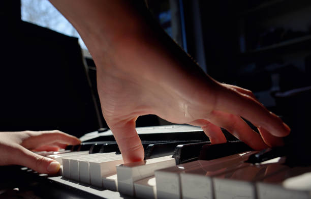 istock Details of Hands playing piano in room 1141945529