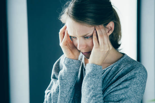istock Sick woman at home massaging temples, feeling strong headache 1141946741