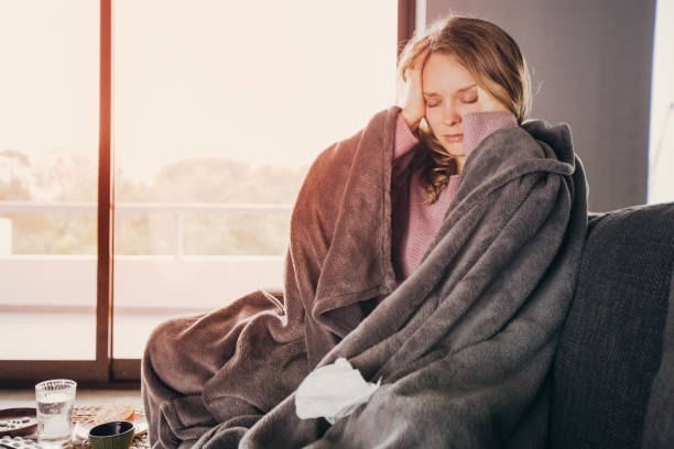 istock Sick young woman having headache, massaging head with fingers 1141946782