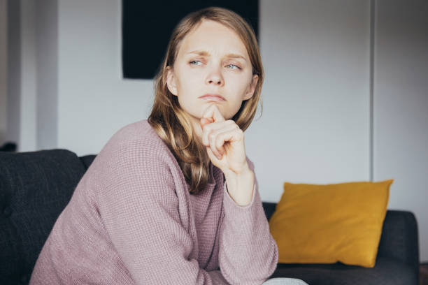 istock Upset young woman keeping fingers on lips 1141946785
