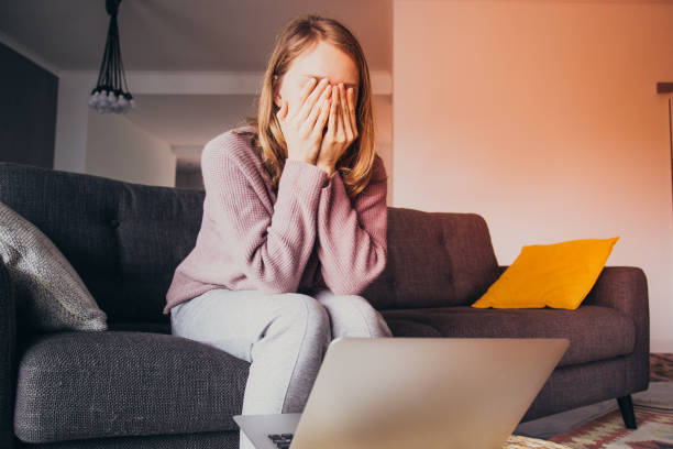 istock Woman at home closing eyes with hands, thinking. Laptop on table 1141946786