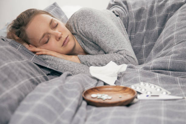 istock Sick young woman lying in bed, sleeping 1141947320