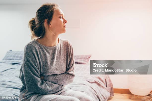 Woman With Hands On Stomach Suffering From Pain Looking Aside Stock Photo - Download Image Now