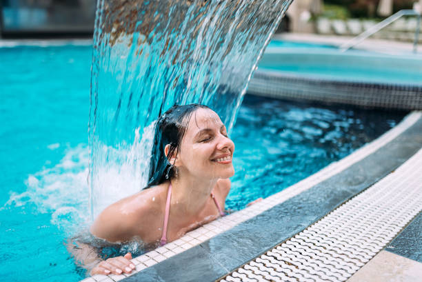 istock Enjoying the waterfall in the swimming pool. 1141947714