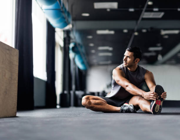 다리 근육 스트레칭 체육관의 바닥에 앉아 라틴어 남성 - stretching exercising men gym 뉴스 사진 이미지