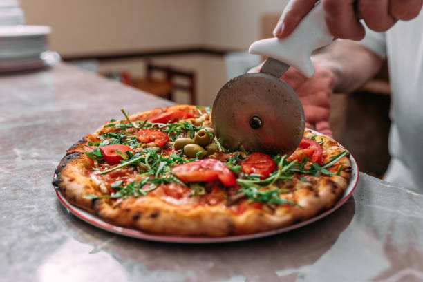 istock Cutting freshly prepared pizza. Close-up. 1141948010