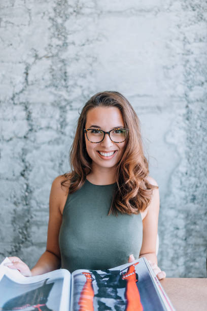 istock Beautiful young woman reading a magazine. 1141948038