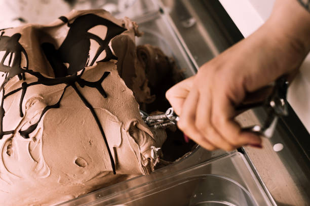 istock Female hand with scoop taking ice cream. Close-up. Top view. 1141948392