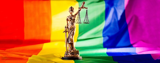 Scales of justice symbol of law and justice with lgbt flag in rainbow colours. Lgbt rights and law
