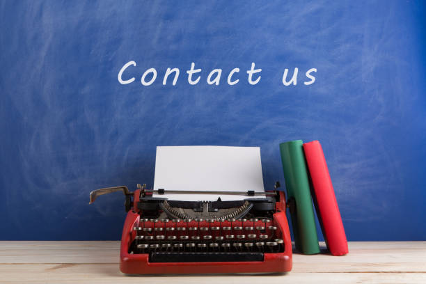 istock writer's workplace - red typewriter and books on blue blackboard background with text 