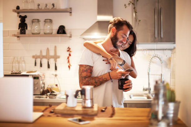 istock Young couple at home using smartphone - Morning breakfast time 1141954691