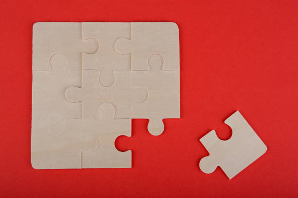 istock Wooden puzzle pieces on a red background 1141954846