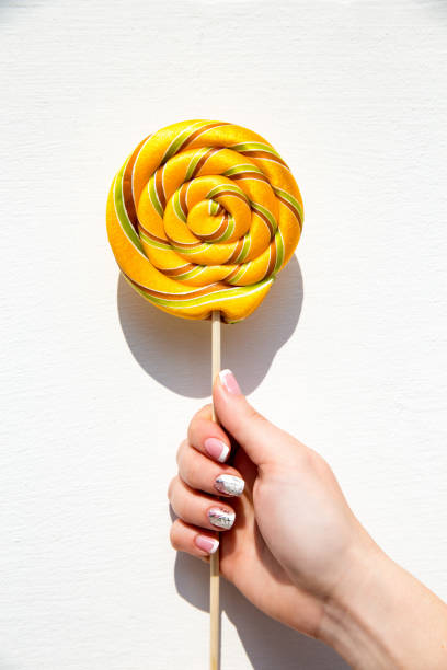 istock Lollypop on a stick ina hand. 1141957087
