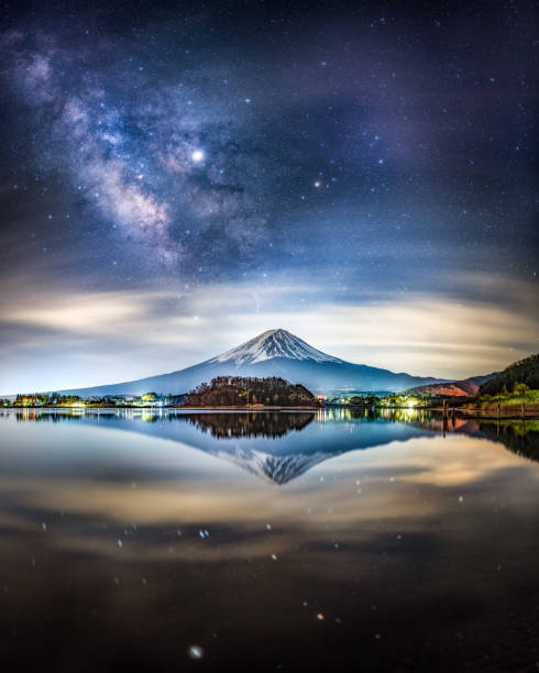 milky way and Mount fuji at night reflected on Lake Kawaguchi, Japan Candid Photo of Snow capped Mount Fuji at night with miky way and Jupiter in the sky, reflected in Lake Kawaguchiko, Yamanashi Prefecture, Japan reflection lake stock pictures, royalty-free photos & images