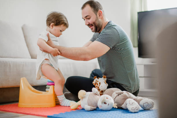 Father training his child to use potty stock photo