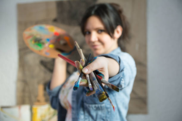 istock Woman with paintbrushes 1141959475