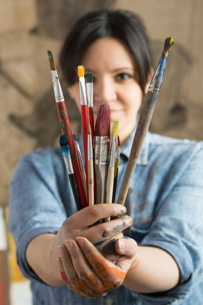 istock Female artist holding paintbrushes 1141959731