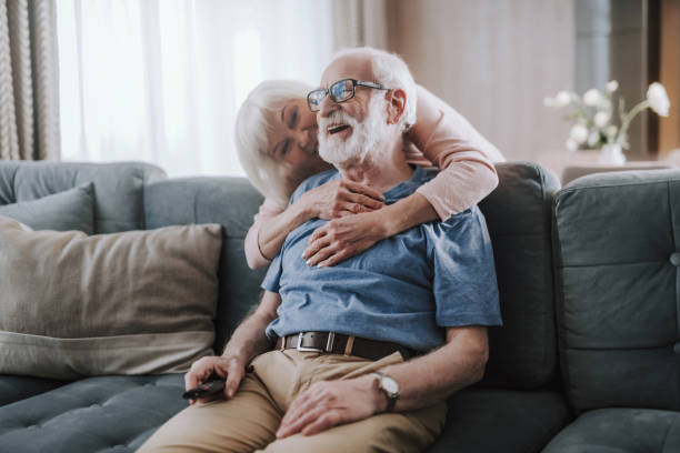 istock Happy elder married couple embracing on sofa 1141960064