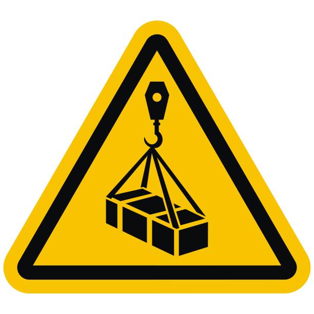 ISO 7010 W015 Warning, Overhead load, vector icon. ISO 7010 W015 Warning, Overhead load, vector icon. Crane with box at yellow triangle background. Black silhouette at black frame. hanging stock illustrations