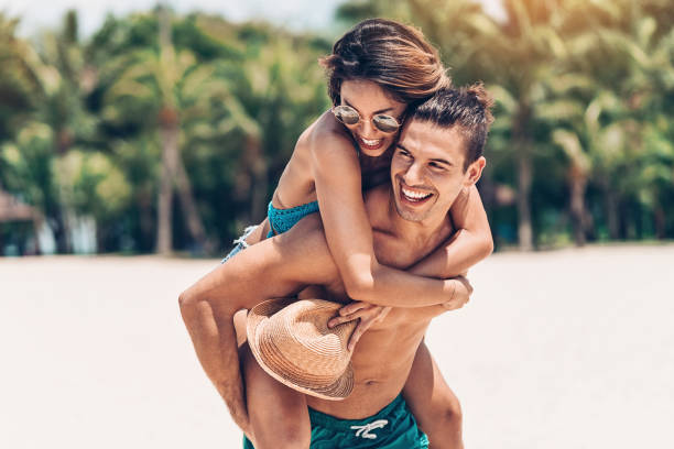 Lovely couple in the summer Multi-ethnic couple having fun on the beach holiday camp stock pictures, royalty-free photos & images