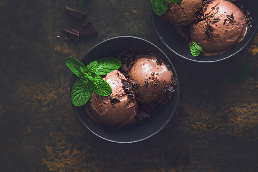 Dark chocolate ice cream in a black bowl, view from above