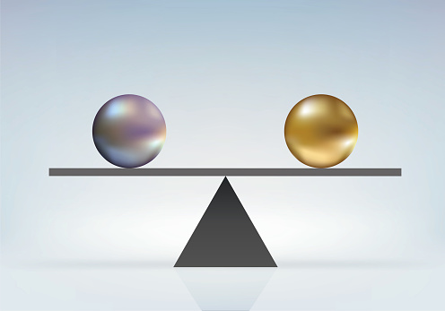 Concept of absolute parity with two balls of the same size but different colors in perfect balance on a scale.