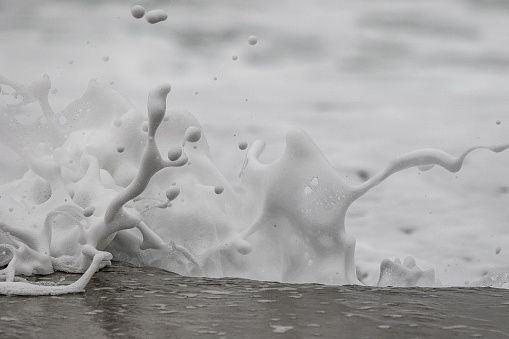 Breakwater crashing up against a rock