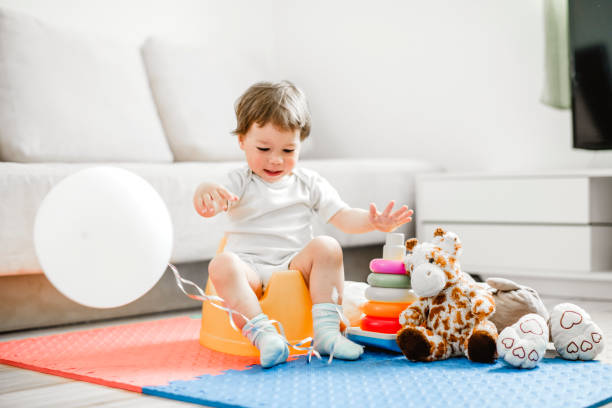 istock Baby boy on yellow potty 1141965336