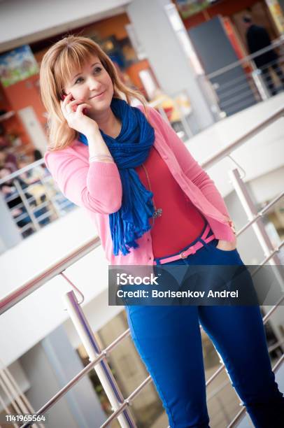 The Girl In The Store Talking On The Phone Red European In Bright Summer Clothes Stock Photo - Download Image Now