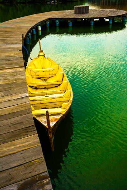 Traditional boats are leaning on a quiet dock. It's boardwalk type dock. Let's go fishing or boating