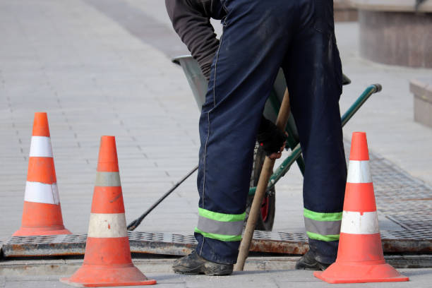 Road work and construction, the worker of municipal services repairs drainage system Wastewater treatment, orange roadblock cones on the city street traffic cone photos stock pictures, royalty-free photos & images