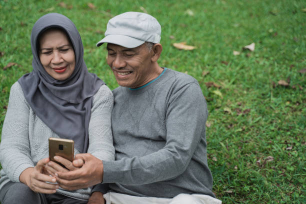 istock senior muslim couple using smartphone together in the park 1141970023