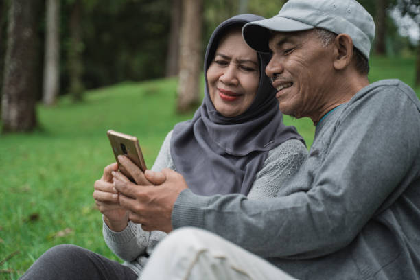 istock old man and woman using mobile phone in the park 1141970156