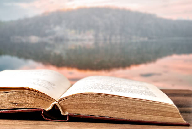 istock open book on a wooden surface and landscape in the background 1141970929