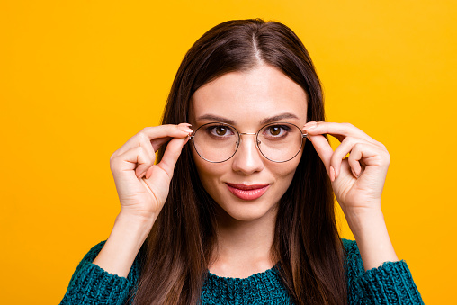 Close-up portrait of her she nice attractive lovely clever smart brainy nerd cheerful cheery straight-haired girl touching round glasses isolated over bright vivid shine yellow background