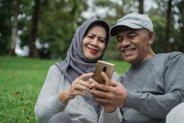 istock old man and woman using mobile phone in the park 1141970947