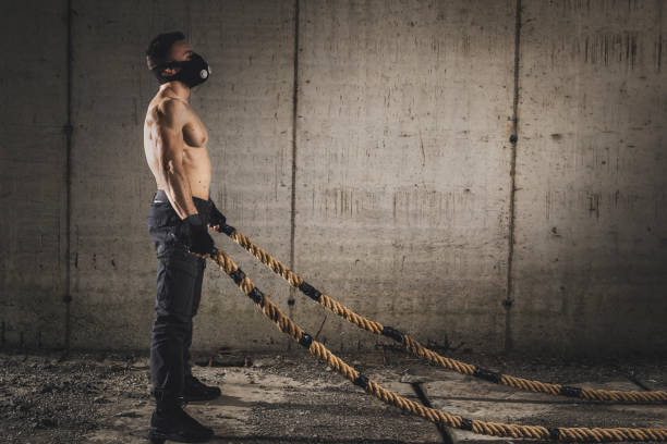 istock Muscular man doing battle ropes workout 1141972581