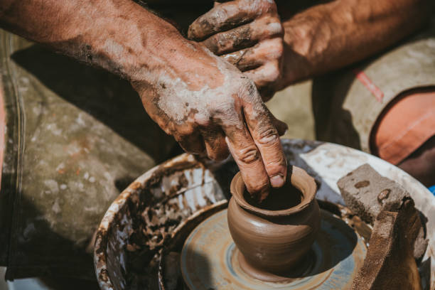 istock Master hands makes a pot of clay. Master class is held in nature, close-up 1141974260