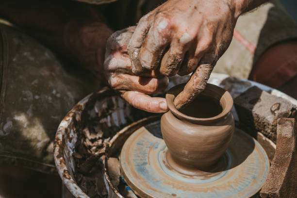 istock Master hands makes a pot of clay. Master class is held in nature, close-up 1141974365