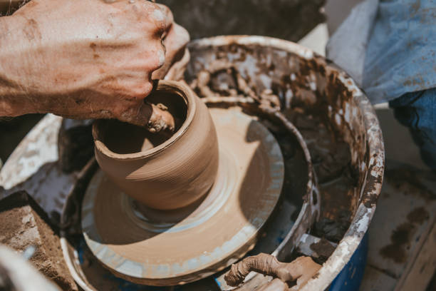 istock Master hands makes a pot of clay. Master class is held in nature, close-up 1141974395