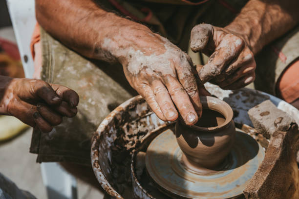 istock Master hands makes a pot of clay. Master class is held in nature, close-up 1141974590