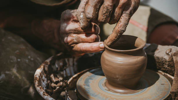 istock Master hands makes a pot of clay. Master class is held in nature, close-up 1141974740