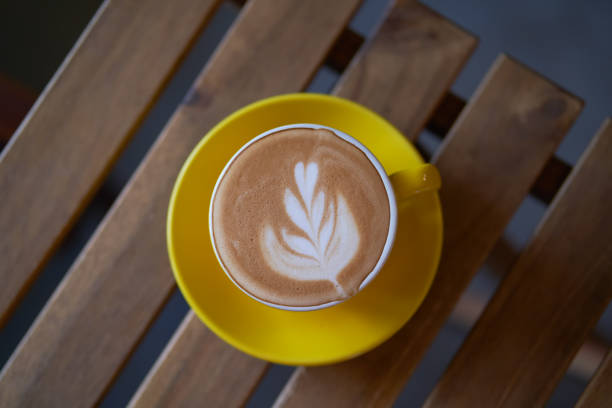 istock Latte in a yellow cup on wooden table 1141975811