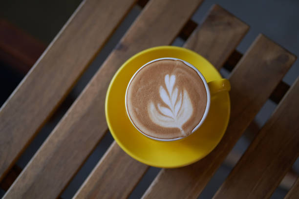 istock Latte in a yellow cup on wooden table 1141975825